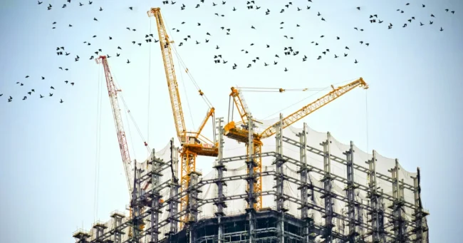 Grúas sobre un edificio en construcción con andamios