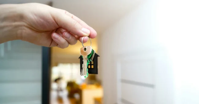 Promesa de compraventa en Chile Mano con las llaves de una vivienda frente a la entrada