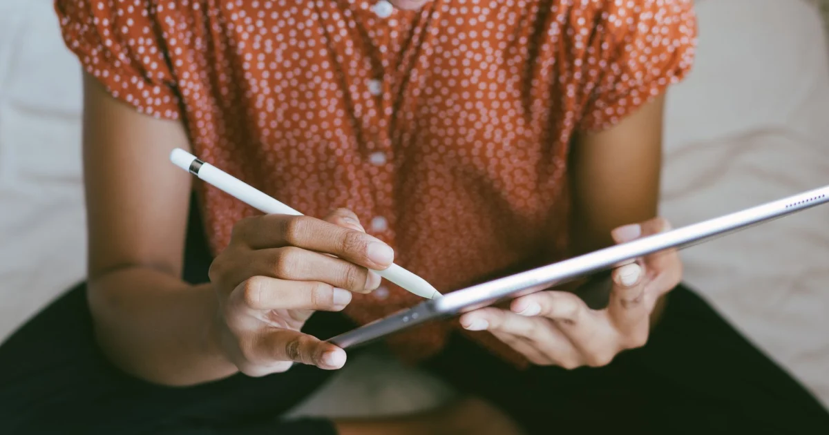 Persona escribe con un lápiz digital en una tablet
